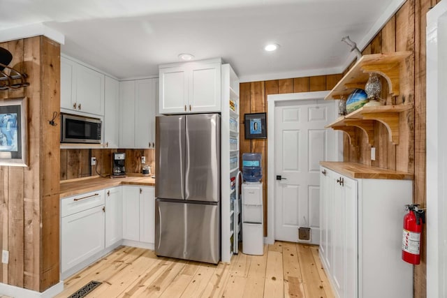 kitchen featuring stainless steel appliances, wood counters, white cabinets, open shelves, and light wood finished floors