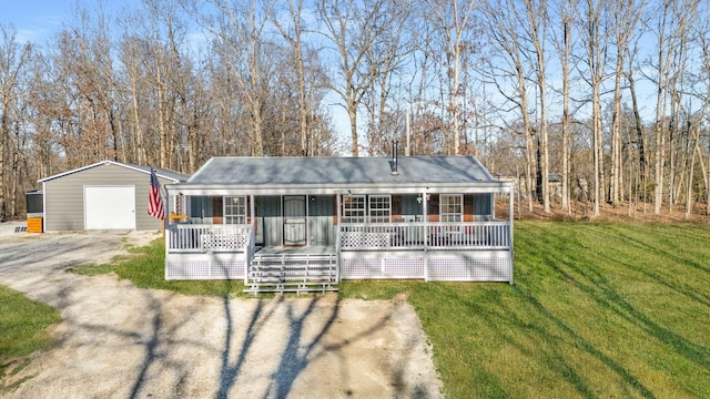 single story home featuring a porch, a garage, an outdoor structure, dirt driveway, and a front lawn