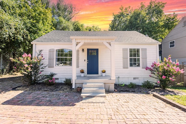 bungalow featuring crawl space, a shingled roof, and fence