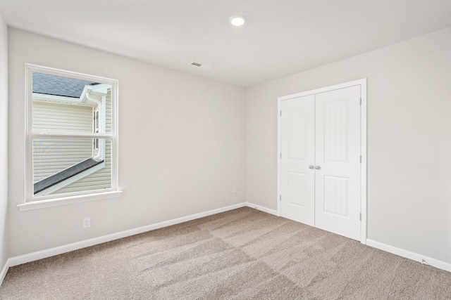 unfurnished bedroom with visible vents, baseboards, carpet, a closet, and recessed lighting