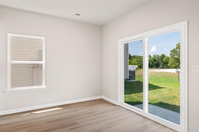 empty room featuring baseboards, visible vents, and wood finished floors