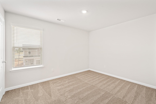 carpeted empty room featuring visible vents and baseboards