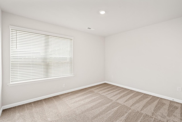 carpeted empty room featuring a healthy amount of sunlight, recessed lighting, and baseboards