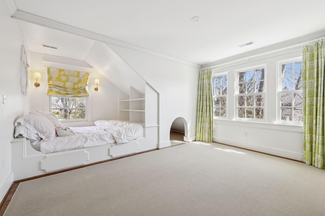 carpeted bedroom featuring baseboards, visible vents, and crown molding