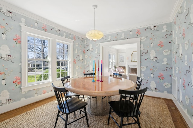 dining space featuring light wood-style flooring, baseboards, and wallpapered walls