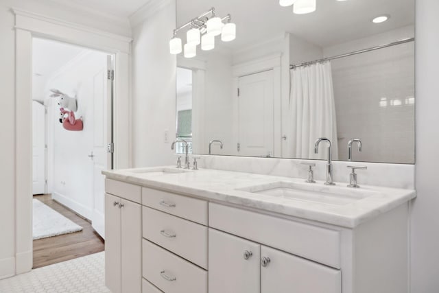 full bathroom with double vanity, curtained shower, a sink, and crown molding