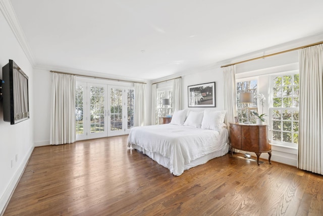 bedroom with wood finished floors, access to exterior, baseboards, french doors, and crown molding