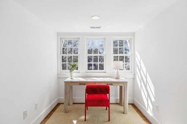 office area with baseboards, visible vents, and wood finished floors