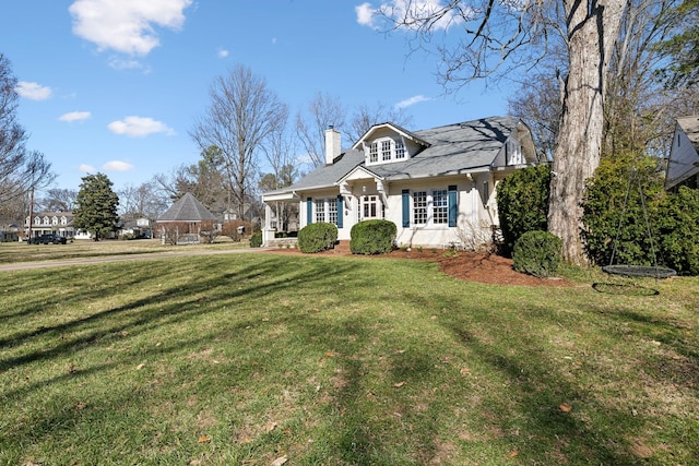 view of front facade featuring a front lawn and a chimney