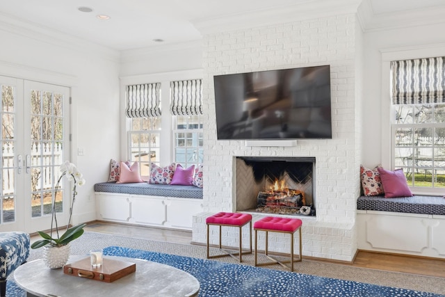 living area featuring ornamental molding, a fireplace, and wood finished floors