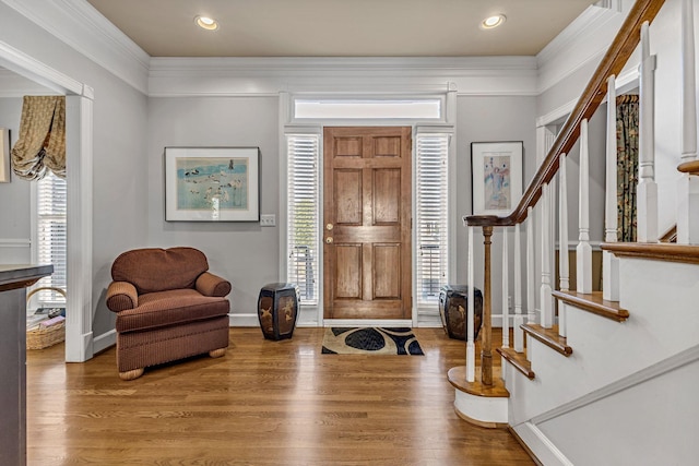 entrance foyer with baseboards, stairway, wood finished floors, and crown molding