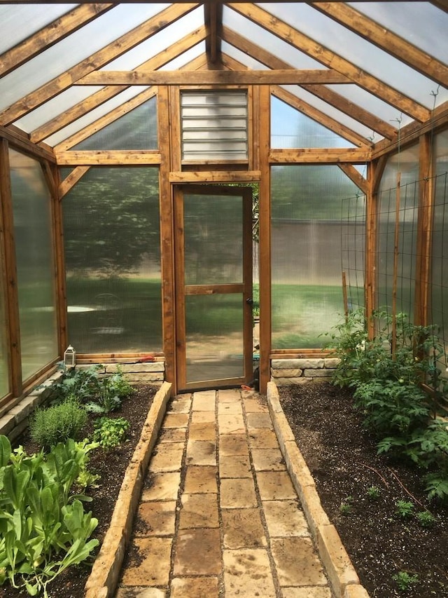 unfurnished sunroom featuring vaulted ceiling