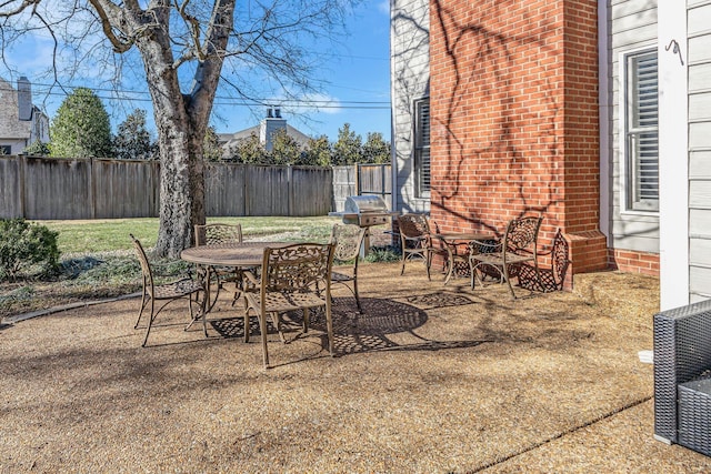 view of patio / terrace with outdoor dining area, a fenced backyard, and a grill