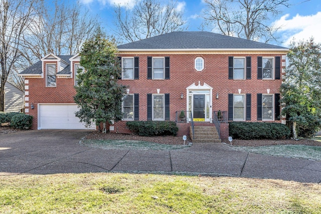 view of front of property featuring an attached garage, roof with shingles, concrete driveway, and brick siding