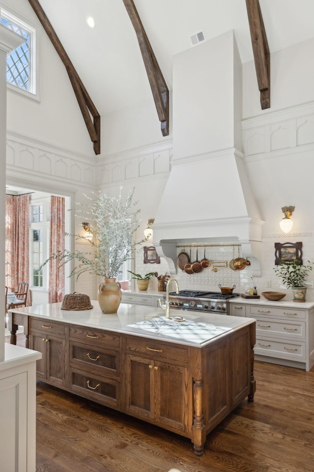 kitchen with high vaulted ceiling, premium range hood, light countertops, beam ceiling, and dark wood finished floors