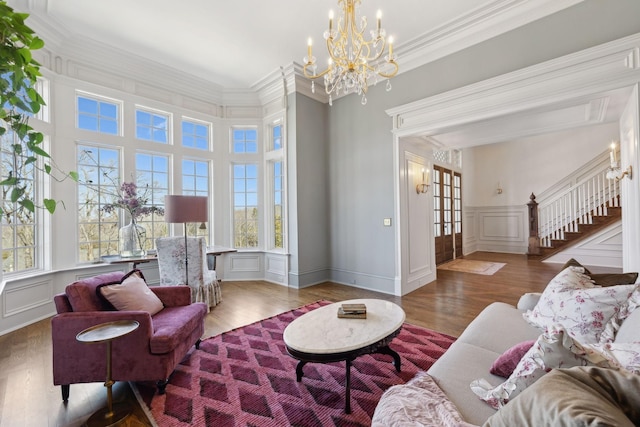 living room featuring ornamental molding, stairway, wood finished floors, and a decorative wall