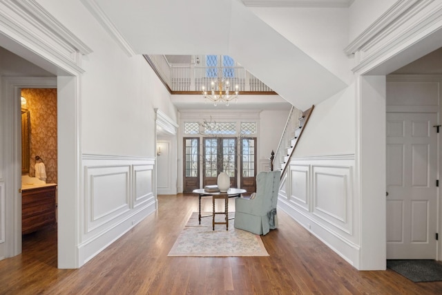 living area with a decorative wall, a notable chandelier, and wood finished floors