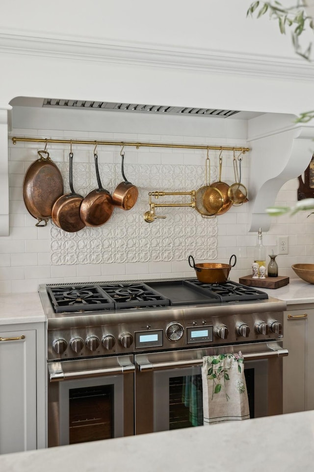 kitchen featuring double oven range, ornamental molding, and tasteful backsplash