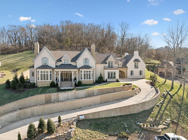 view of front of house featuring fence, a chimney, and a front lawn