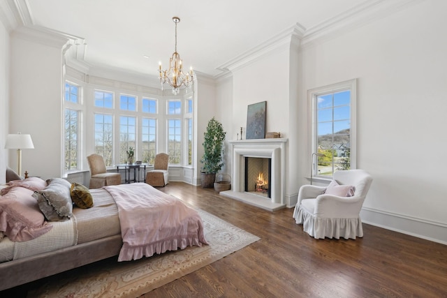 bedroom with a lit fireplace, multiple windows, crown molding, and wood finished floors