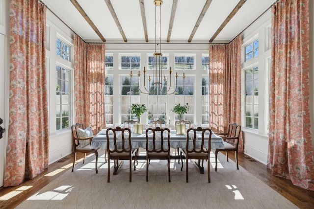 sunroom with beamed ceiling and an inviting chandelier