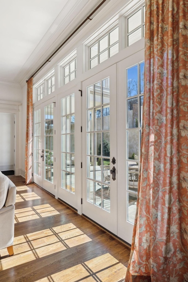 doorway with ornamental molding, french doors, and wood-type flooring