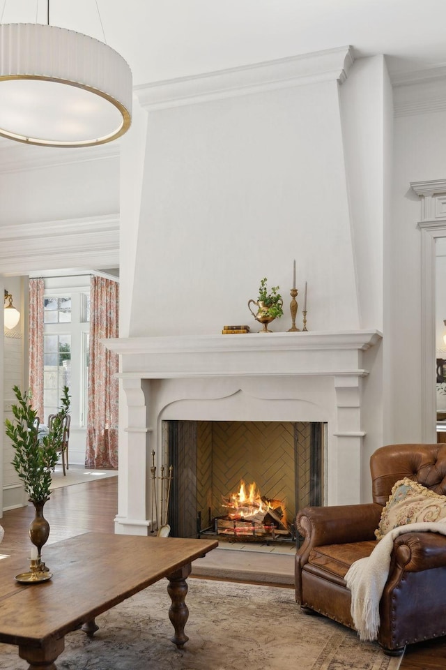 living area featuring a warm lit fireplace and ornamental molding