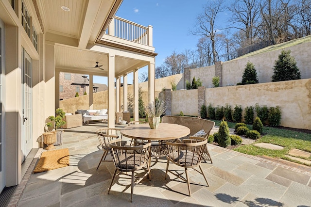 view of patio / terrace featuring a balcony, a fenced backyard, an outdoor living space, and outdoor dining space