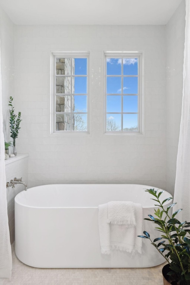 full bath with a soaking tub and tile walls