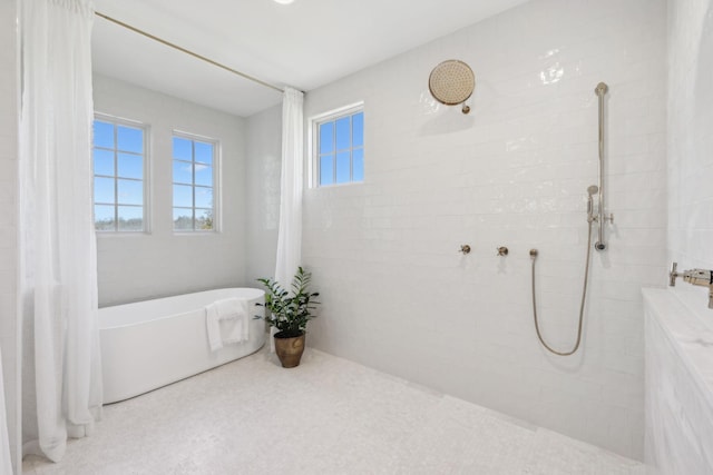 full bathroom with tiled shower and a soaking tub