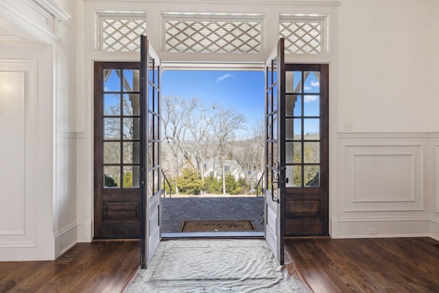 entrance foyer featuring wainscoting, wood finished floors, and a decorative wall