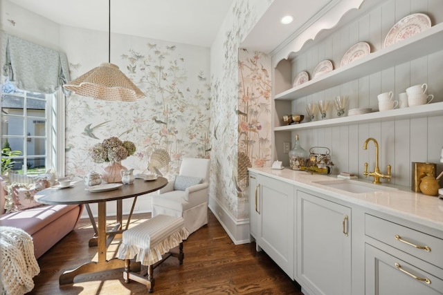 interior space with wallpapered walls, built in features, dark wood-type flooring, and a sink