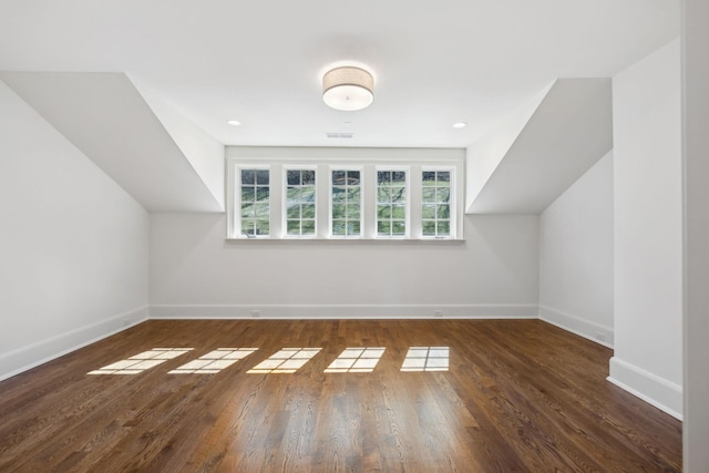 bonus room featuring lofted ceiling, wood finished floors, visible vents, and baseboards