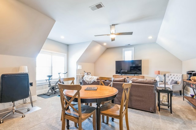 dining area with light colored carpet, a ceiling fan, baseboards, vaulted ceiling, and visible vents