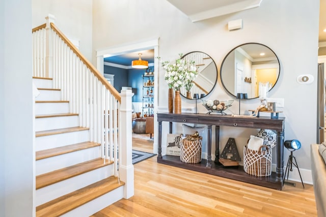 foyer entrance featuring stairs, wood finished floors, and baseboards