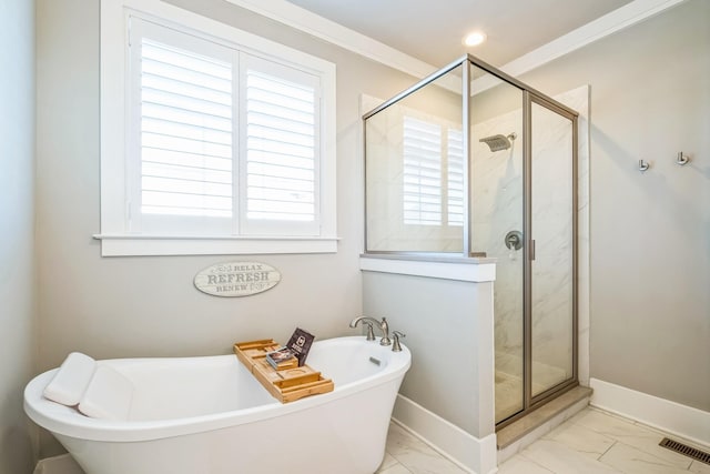 bathroom with marble finish floor, crown molding, a soaking tub, a shower stall, and baseboards