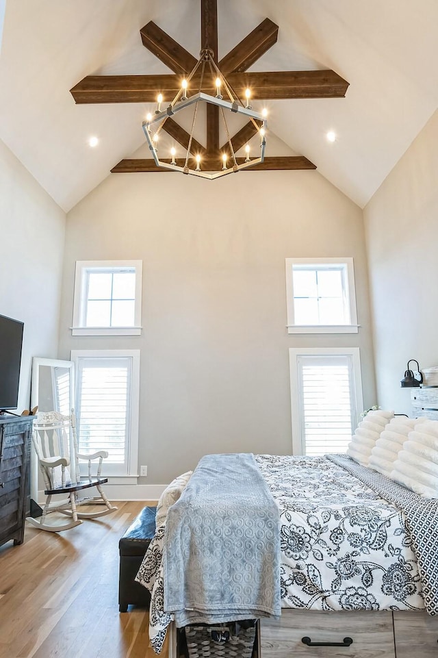 bedroom with high vaulted ceiling, beam ceiling, and wood finished floors