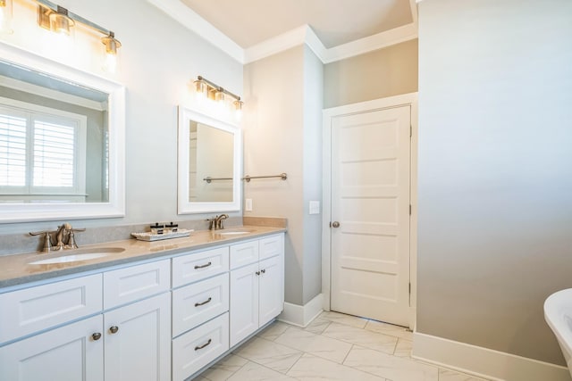 bathroom featuring marble finish floor, ornamental molding, a sink, and baseboards