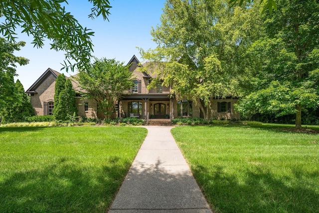 view of front of property with a front lawn and brick siding