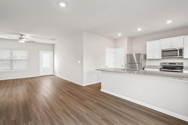 kitchen with dark wood-style flooring, recessed lighting, appliances with stainless steel finishes, a sink, and baseboards