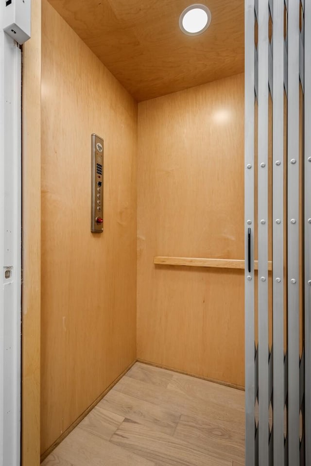 hall featuring wooden ceiling, elevator, and wood finished floors