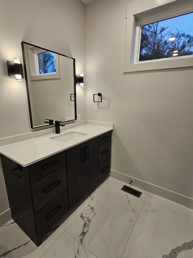 bathroom with marble finish floor, visible vents, vanity, and baseboards