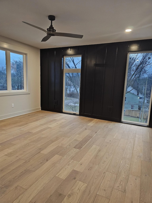 unfurnished room featuring light wood-style floors, ceiling fan, and baseboards