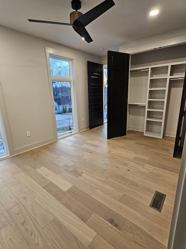 unfurnished bedroom featuring baseboards, visible vents, a ceiling fan, light wood-style floors, and recessed lighting