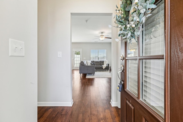 corridor featuring dark wood-style flooring and baseboards