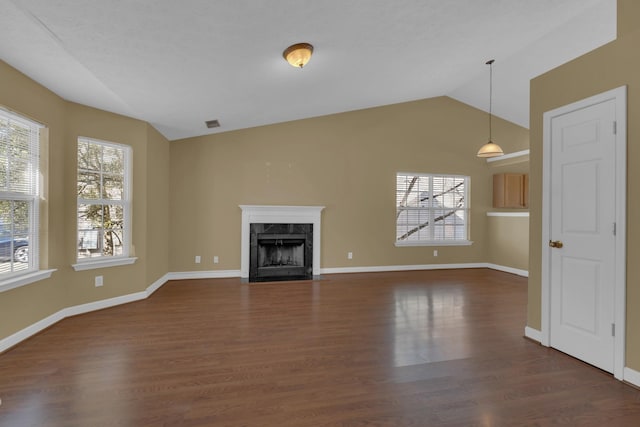 unfurnished living room featuring a premium fireplace, baseboards, vaulted ceiling, and dark wood-type flooring