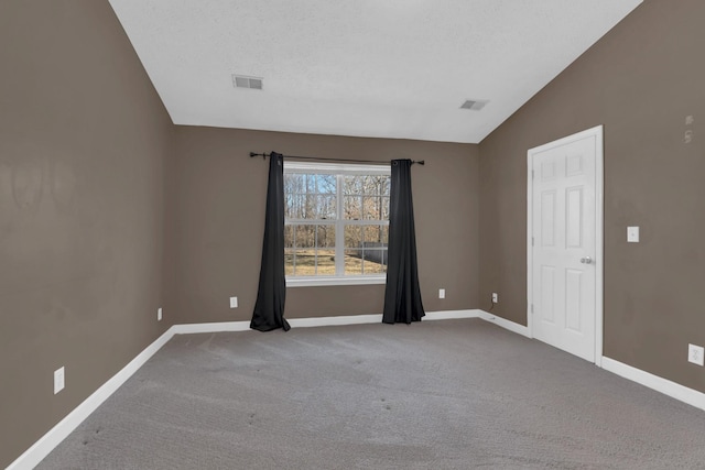 spare room featuring lofted ceiling, carpet floors, visible vents, and baseboards