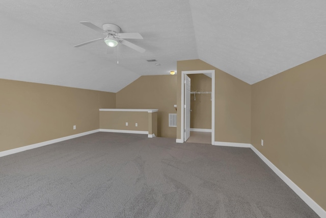 bonus room with visible vents, vaulted ceiling, a textured ceiling, ceiling fan, and baseboards