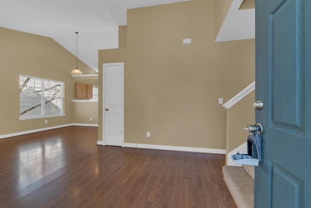 interior space with high vaulted ceiling, dark wood-style flooring, and baseboards