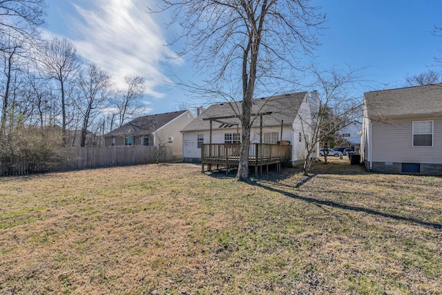 rear view of house featuring a yard, fence, and a wooden deck